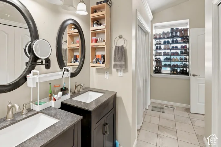 Dual vanity with undermount sinks, dark wood-finish cabinetry, and textured countertops