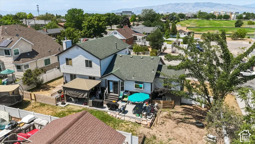 Rear exterior featuring a multi-level deck, covered patio, and mature landscaping
