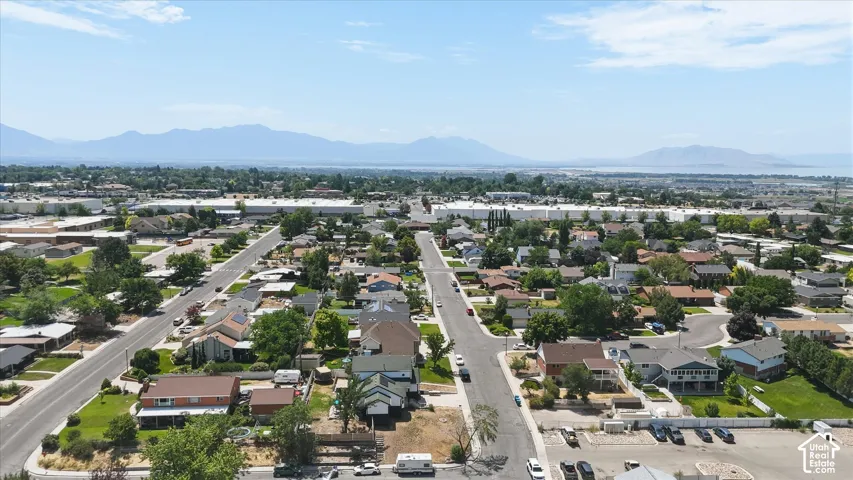 Expansive aerial perspective showcasing a residential neighborhood with distant mountains and a body of water