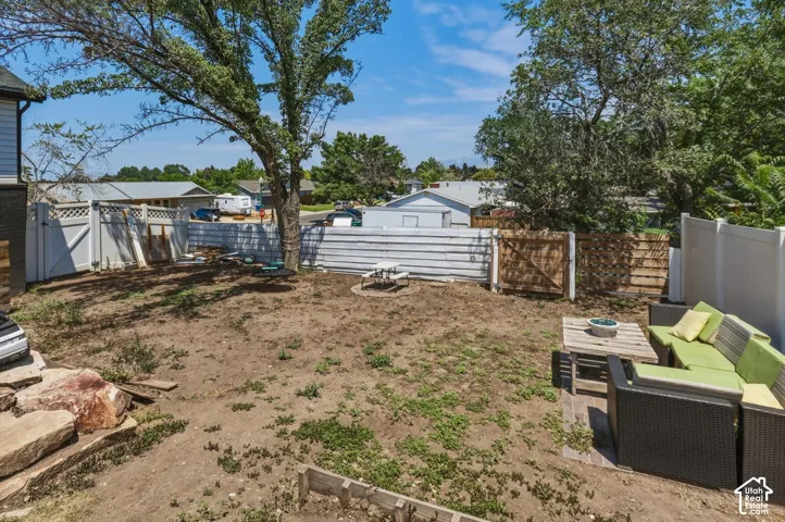Backyard area featuring diverse fencing, mature trees, and a fire pit