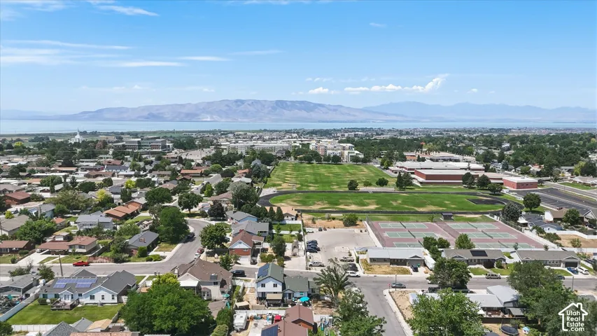 Expansive neighborhood setting with numerous residential properties, prominent green spaces, and mountain scenery