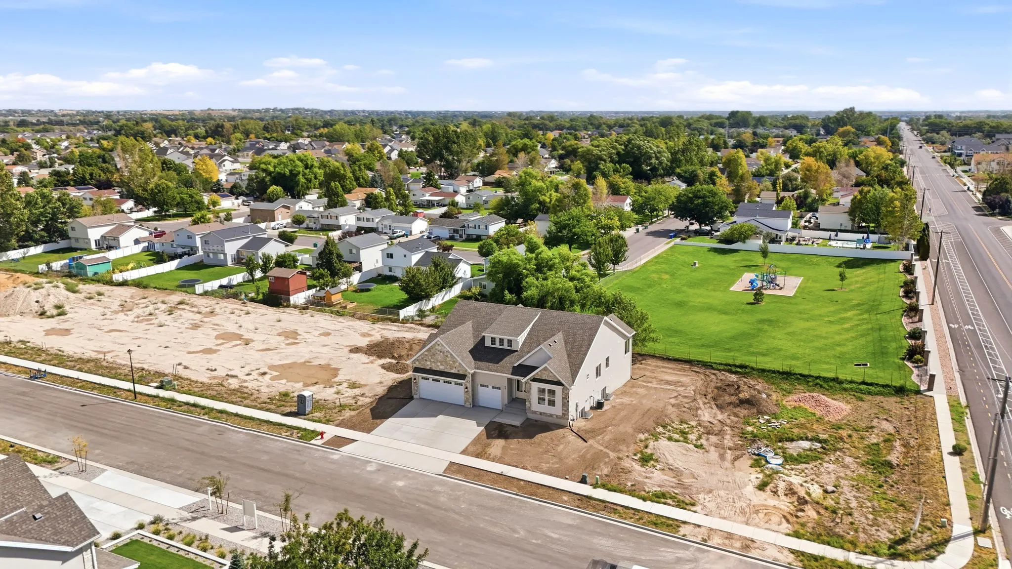 New construction residence featuring a two-car garage, concrete driveway, and light-colored siding with stone accents