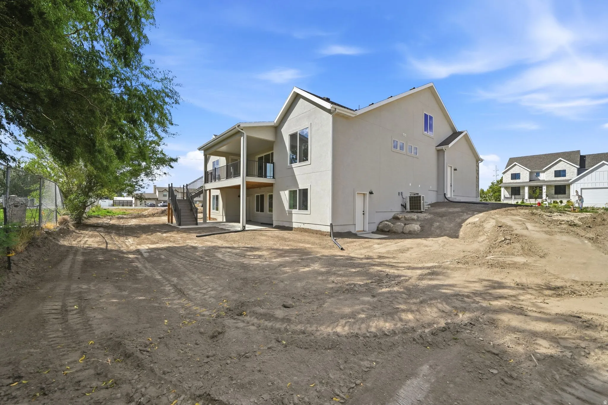 Multi-level rear exterior with covered balcony and patio