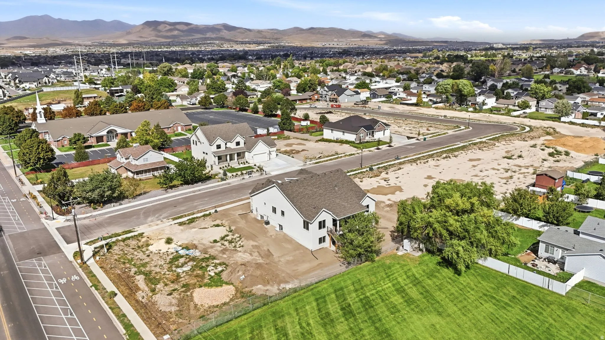 Expansive lot with mountain backdrop, surrounded by established residential areas and undeveloped land