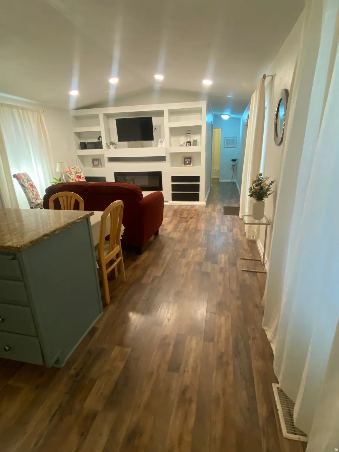 Living area featuring recessed lighting, a built-in media center with shelving, a fireplace, and wood-finish flooring