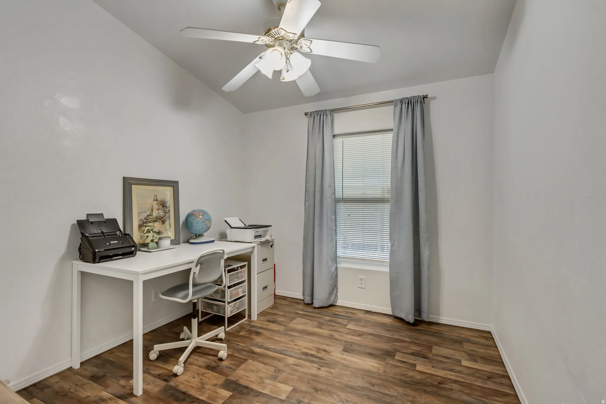 Vaulted ceiling, wood-finish flooring, ceiling fan, and window with blinds