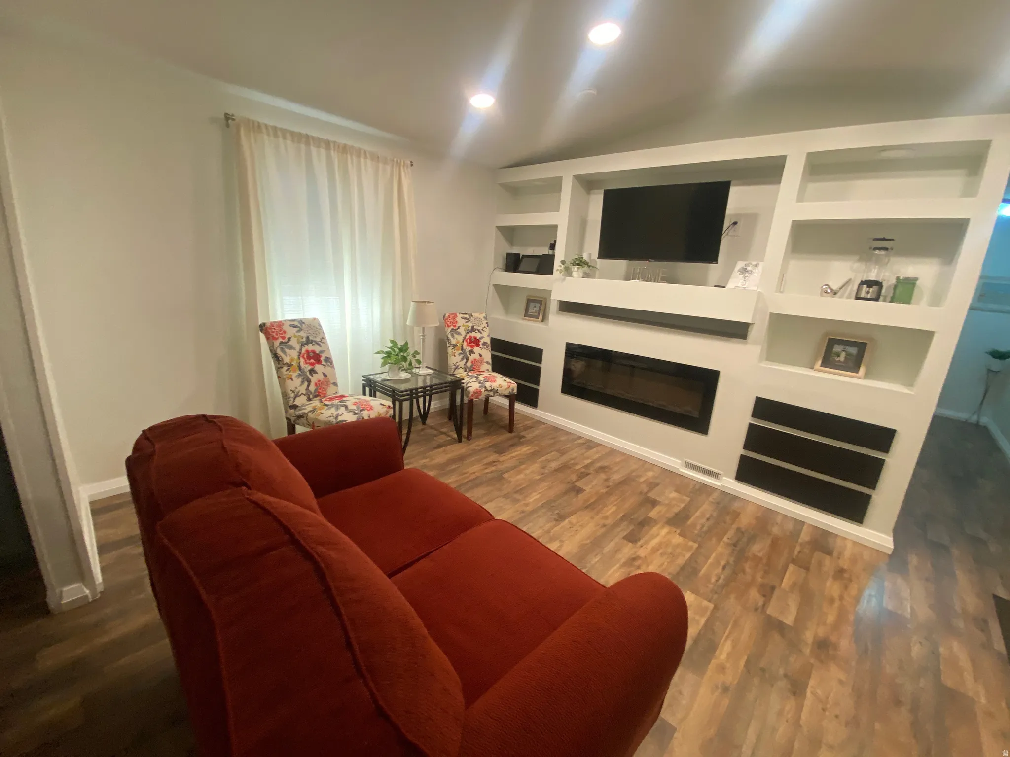 Built-in entertainment center with integrated shelving, inset fireplace, and recessed lighting