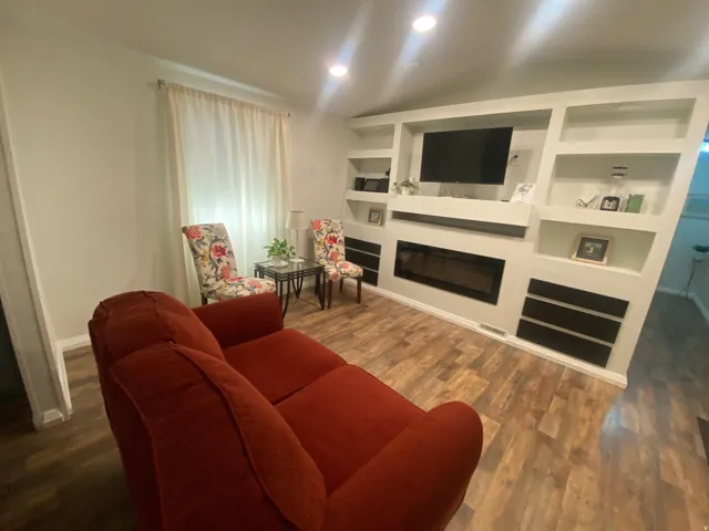 Built-in entertainment center with integrated shelving, inset fireplace, and recessed lighting