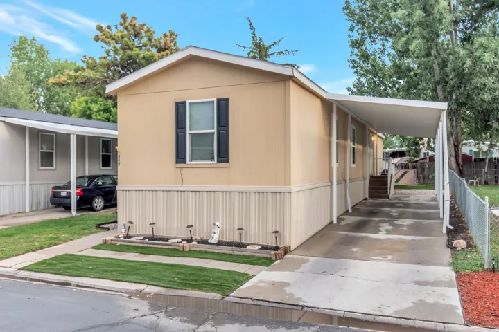 Single-story residence with a covered carport, concrete driveway, and a front window with shutters