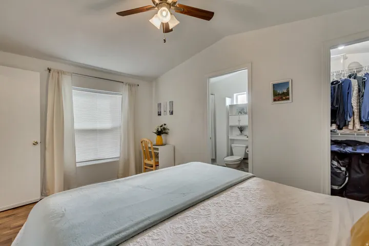 Vaulted ceiling, ceiling fan, wood-finish flooring, white window blinds, and organized closet