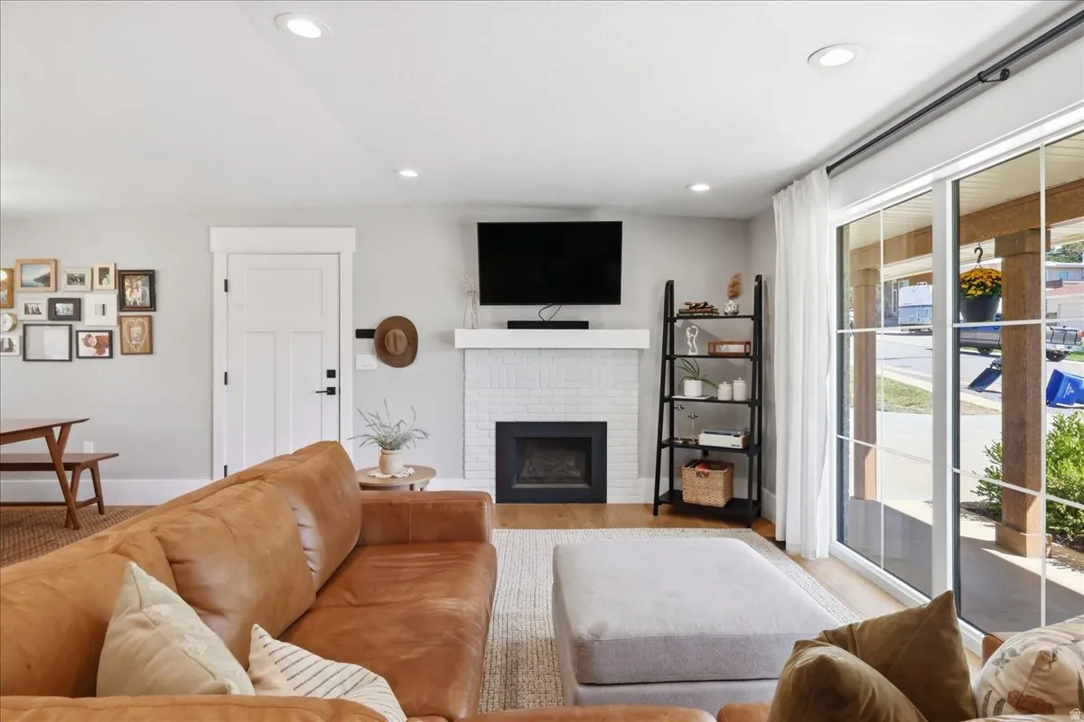 Recessed lighting, wood-finish flooring, white brick fireplace,  covered porch