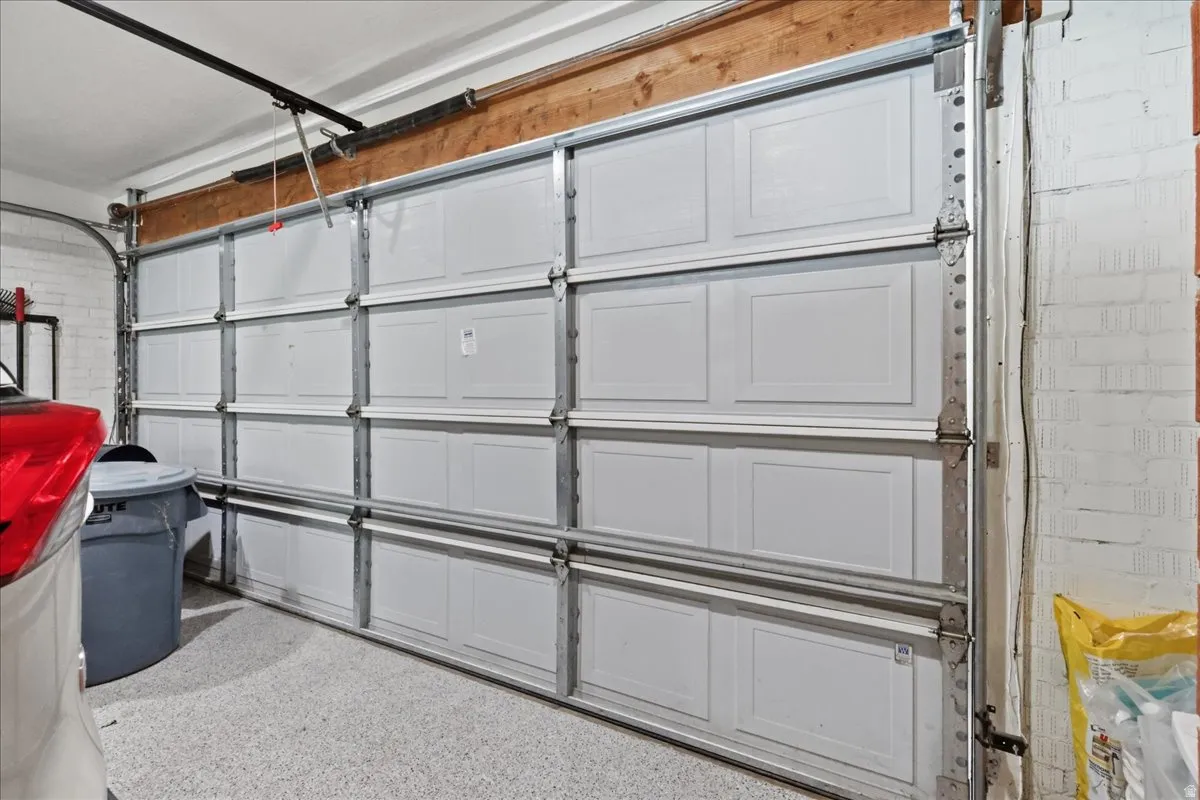White paneled garage door with track system and epoxy-finished flooring