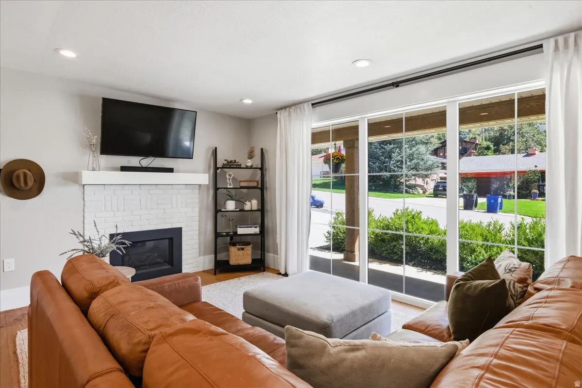 Recessed lighting, wood-finish flooring, white brick fireplace