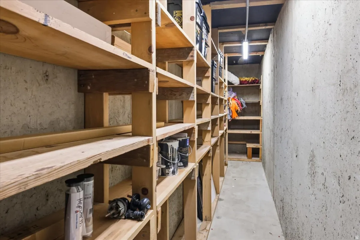Extensive built-in wood shelving, concrete walls, concrete flooring, and ceiling-mounted lighting