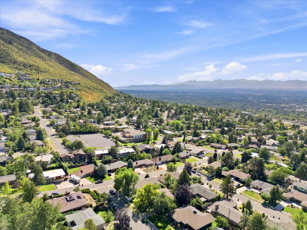 Expansive residential area featuring a diverse mix of homes, mature trees, and mountainous topography