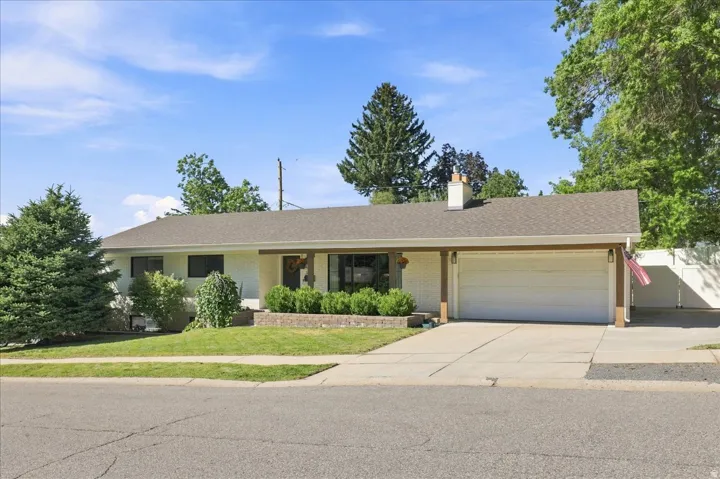 Ranch-style exterior with a brown shingle roof, attached two-car garage, and a covered entryway