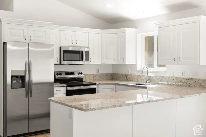White cabinetry, stainless steel appliances, light-toned countertops, and a stainless steel sink with a gooseneck faucet