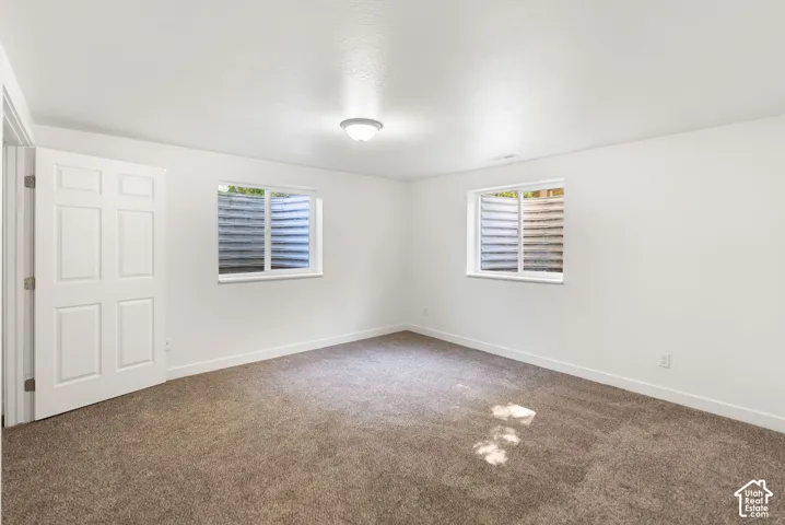 Neutral paint palette, recessed window wells, carpet flooring, flush mount ceiling light, and a six-panel interior door