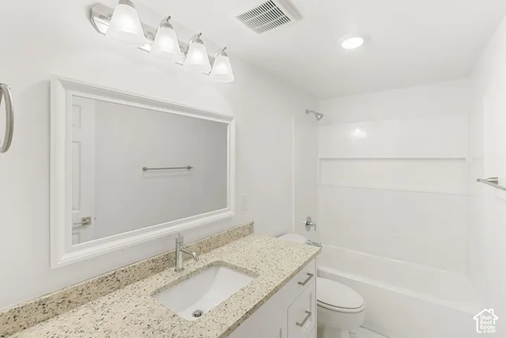 White vanity with a speckled countertop and integrated rectangular sink