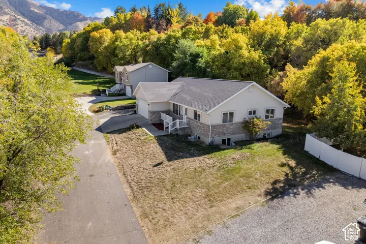 Two-story residence with a two-car garage, white vinyl fencing, and a paved driveway