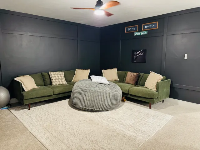 Board and batten accent wall, wood-finish ceiling fan, and carpeted flooring