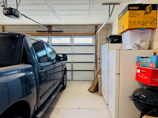 Garage space featuring a paneled overhead door with window inserts and an automatic opener system