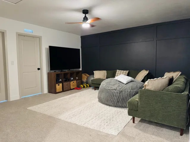 Wall paneling accent feature, neutral carpet flooring, recessed lighting, wood-finish ceiling fan, and paneled interior doors