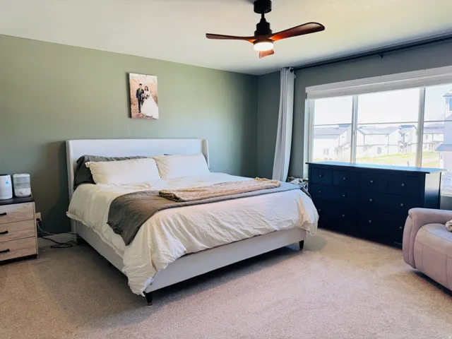 Wall-to-wall carpeting with an overhead ceiling fan