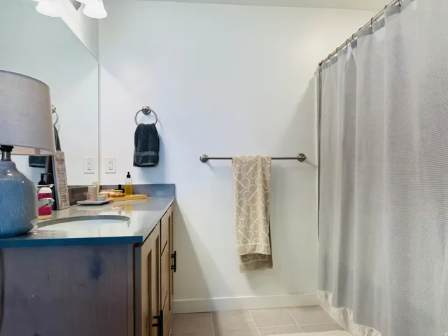 Vanity with a polished countertop, undermount sink, and wood-finish cabinetry