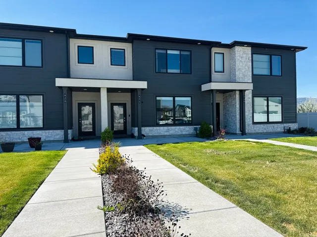 Modern facade with dark siding, light-colored stone accents, and large windows