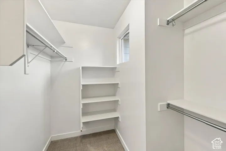 Built-in shelving, multiple hanging rods, durable carpet flooring, and a window