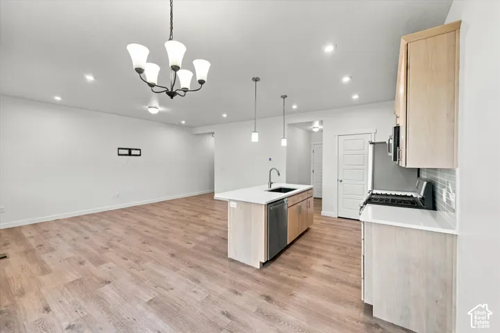 Open-concept living space featuring wood-finish flooring, recessed lighting, and a modern kitchen