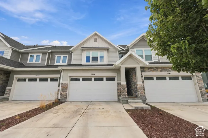 Townhome exterior with light gray siding and stone accents