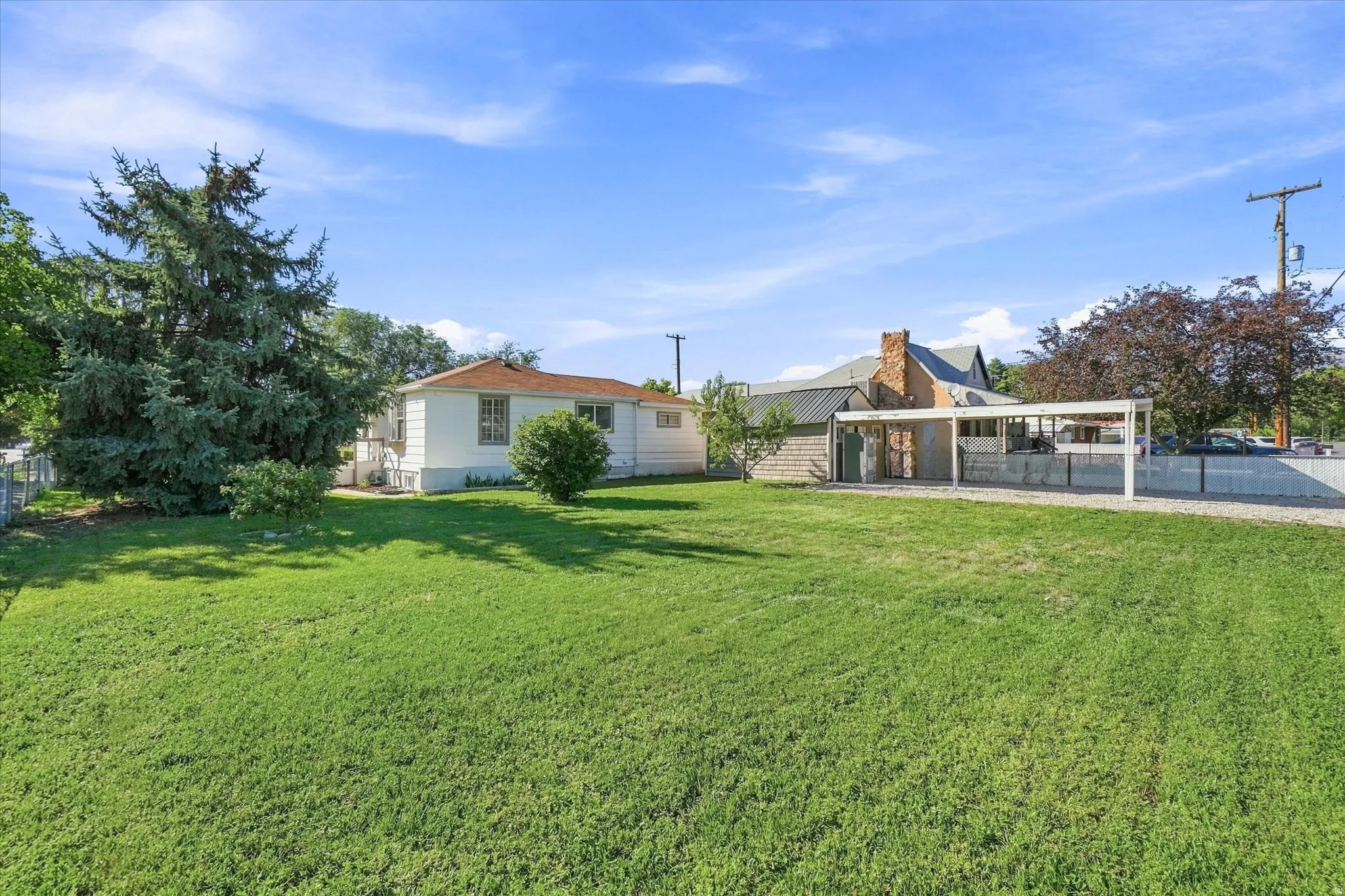 Expansive green lawn with mature trees and shrubs