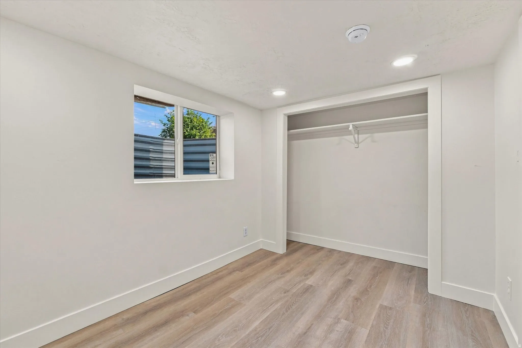 Recessed lighting illuminates the space, complemented by wood-finish flooring