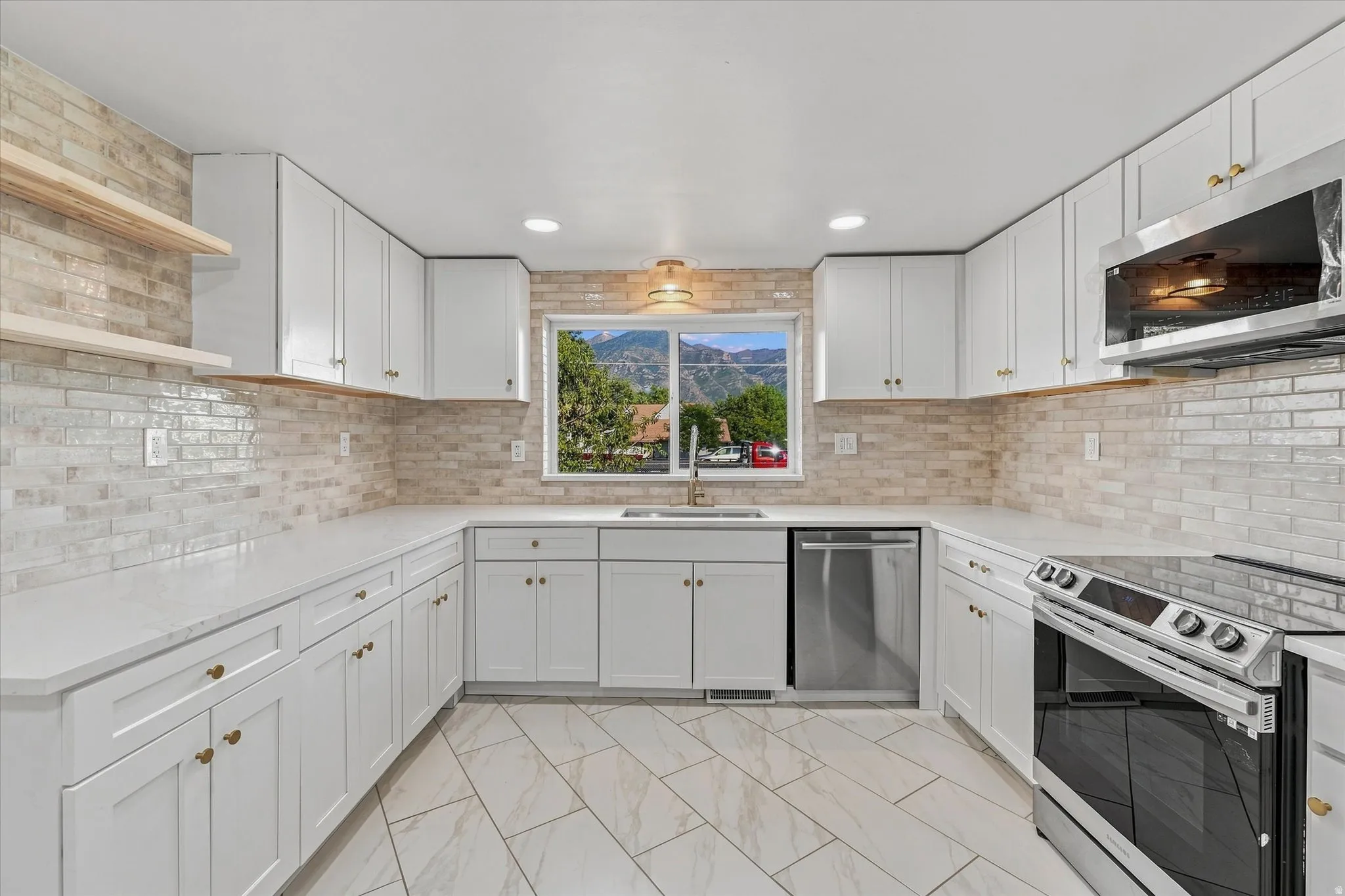 Kitchen featuring white cabinetry, light countertops, a tile backsplash, stainless steel appliances, and wood-finish flooring