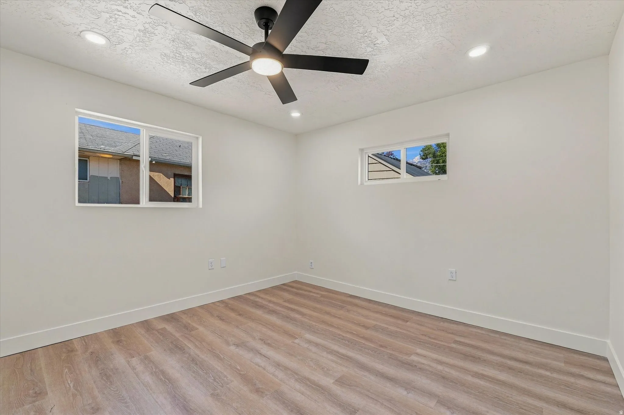 Wood-finish flooring, recessed lighting, and a contemporary ceiling fan with integrated lighting
