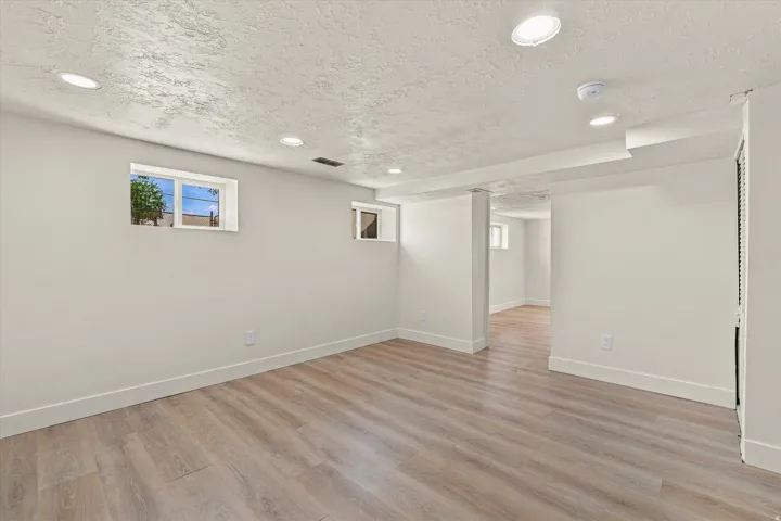Wood-finish flooring with recessed lighting and neutral wall tones