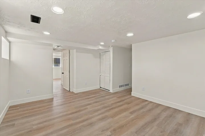 Wood-finish flooring, recessed lighting, white walls, and white trim
