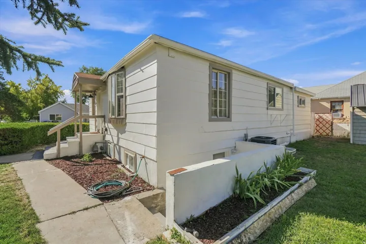 Exterior featuring horizontal siding, multiple window styles, a covered porch with railings, and a concrete pathway