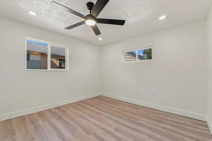 Wood-finish flooring, recessed lighting, and a contemporary ceiling fan with integrated lighting