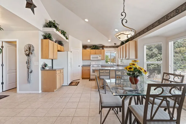 Kitchen. Tile floors. Vaulted Ceilings. Large windows. White appliances. Pantry.