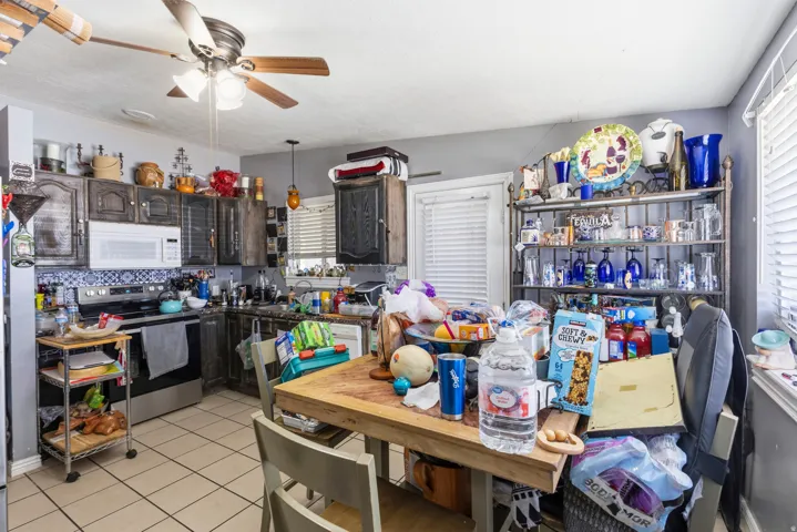 Kitchen featuring ceramic tile flooring, wood cabinetry, built-in microwave, and a ceiling fan with integrated lighting