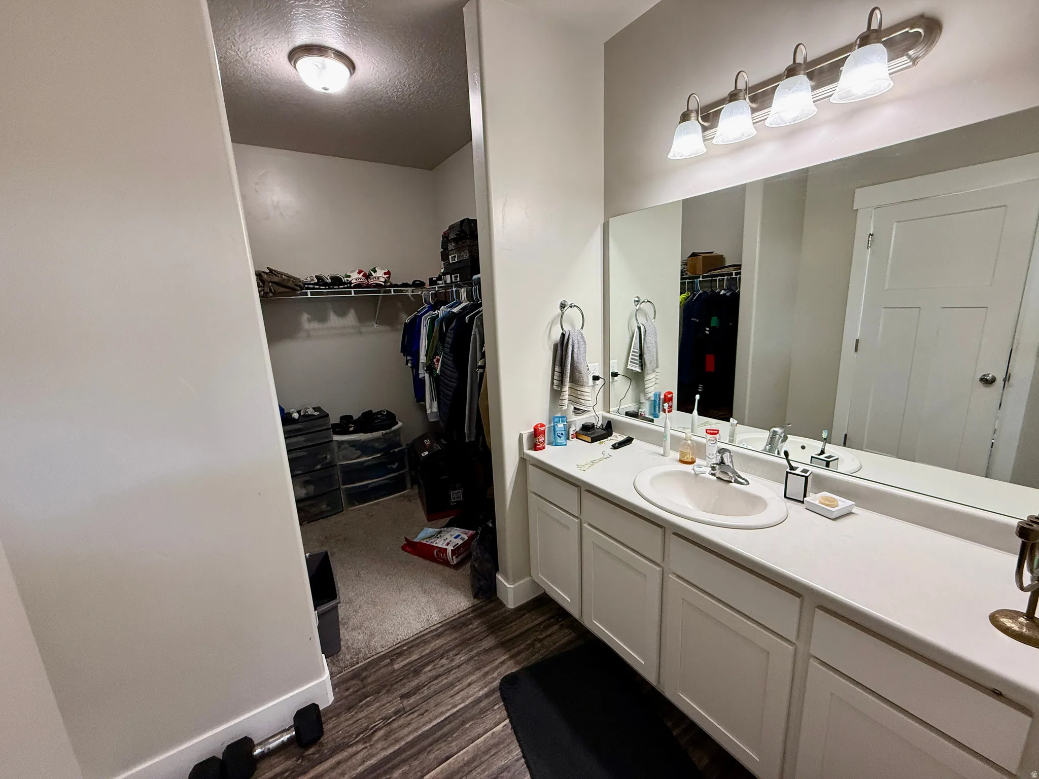 Vanity featuring a single-bowl sink, white cabinetry, and a large mirror