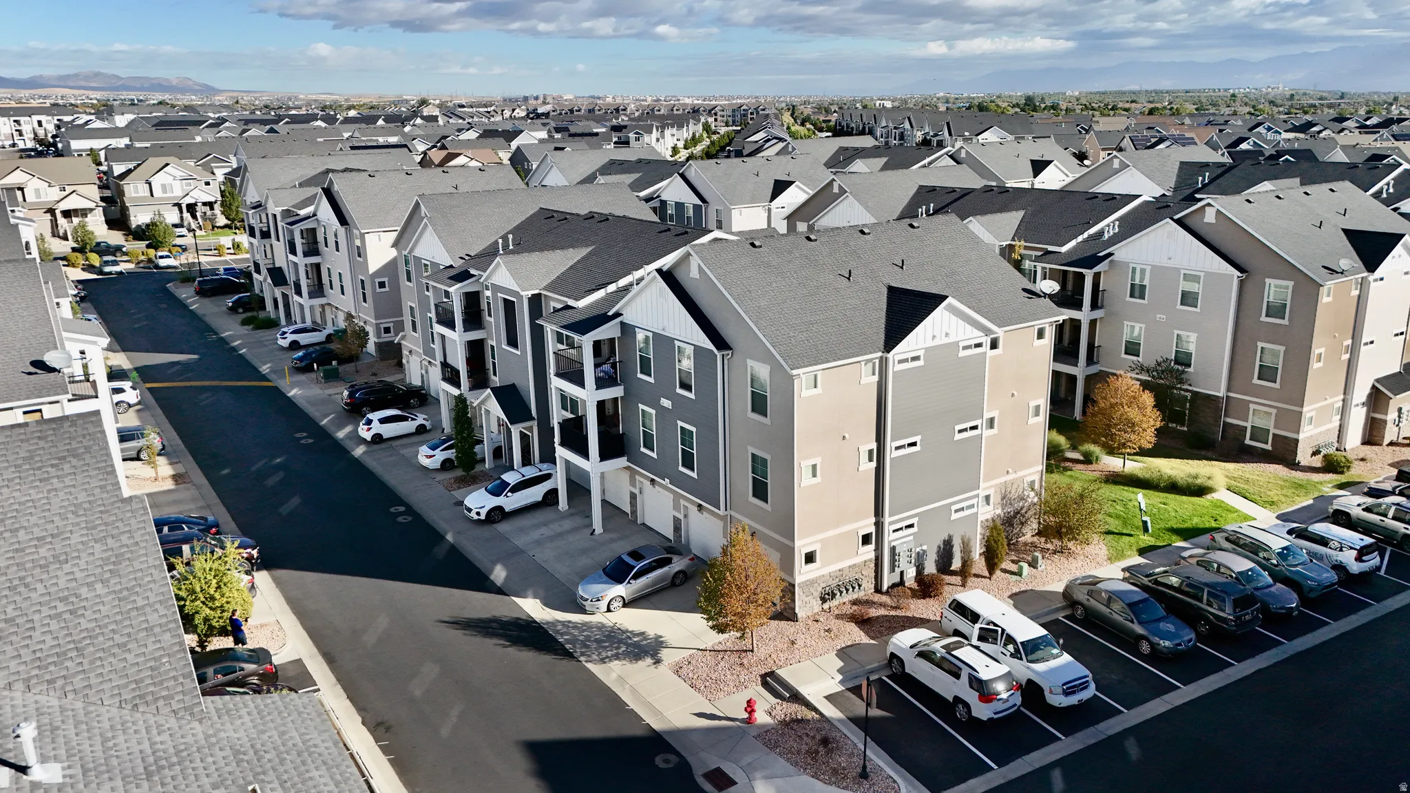 Multiple multi-story buildings featuring varied siding, individual balconies, and attached garages