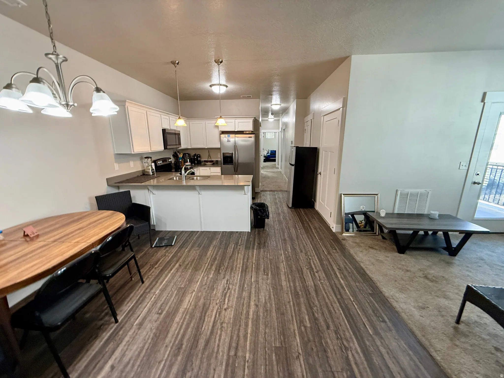 Kitchen featuring white cabinetry, stainless steel appliances, and a central island