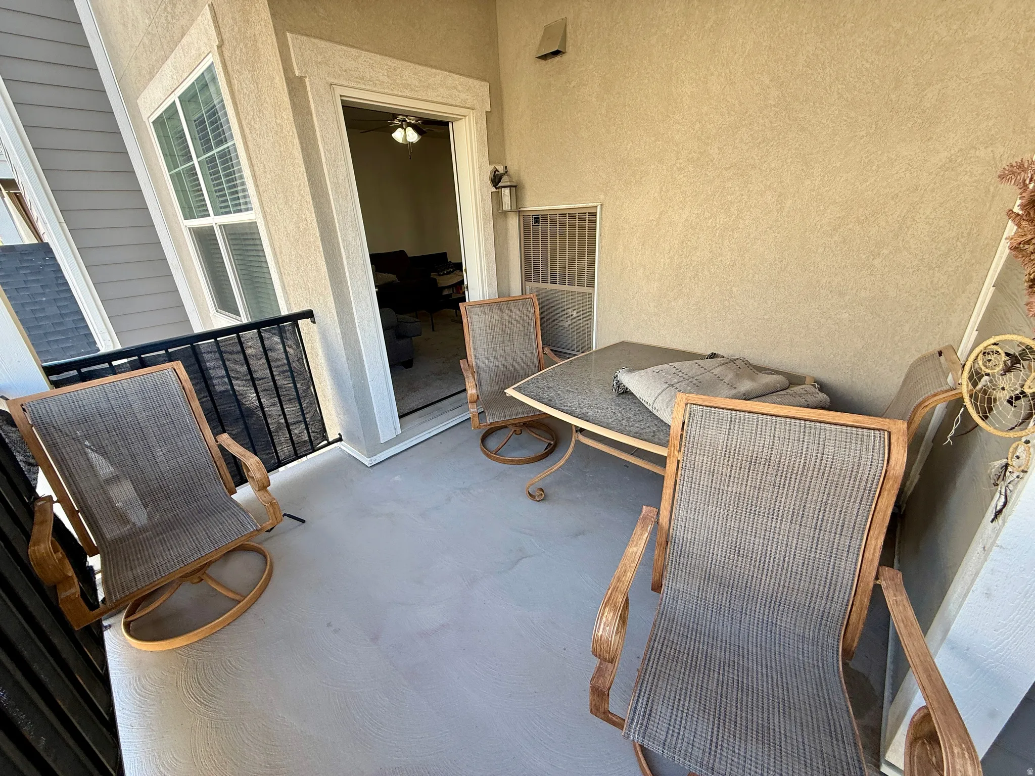 Outdoor patio with textured wall finish and a black metal railing