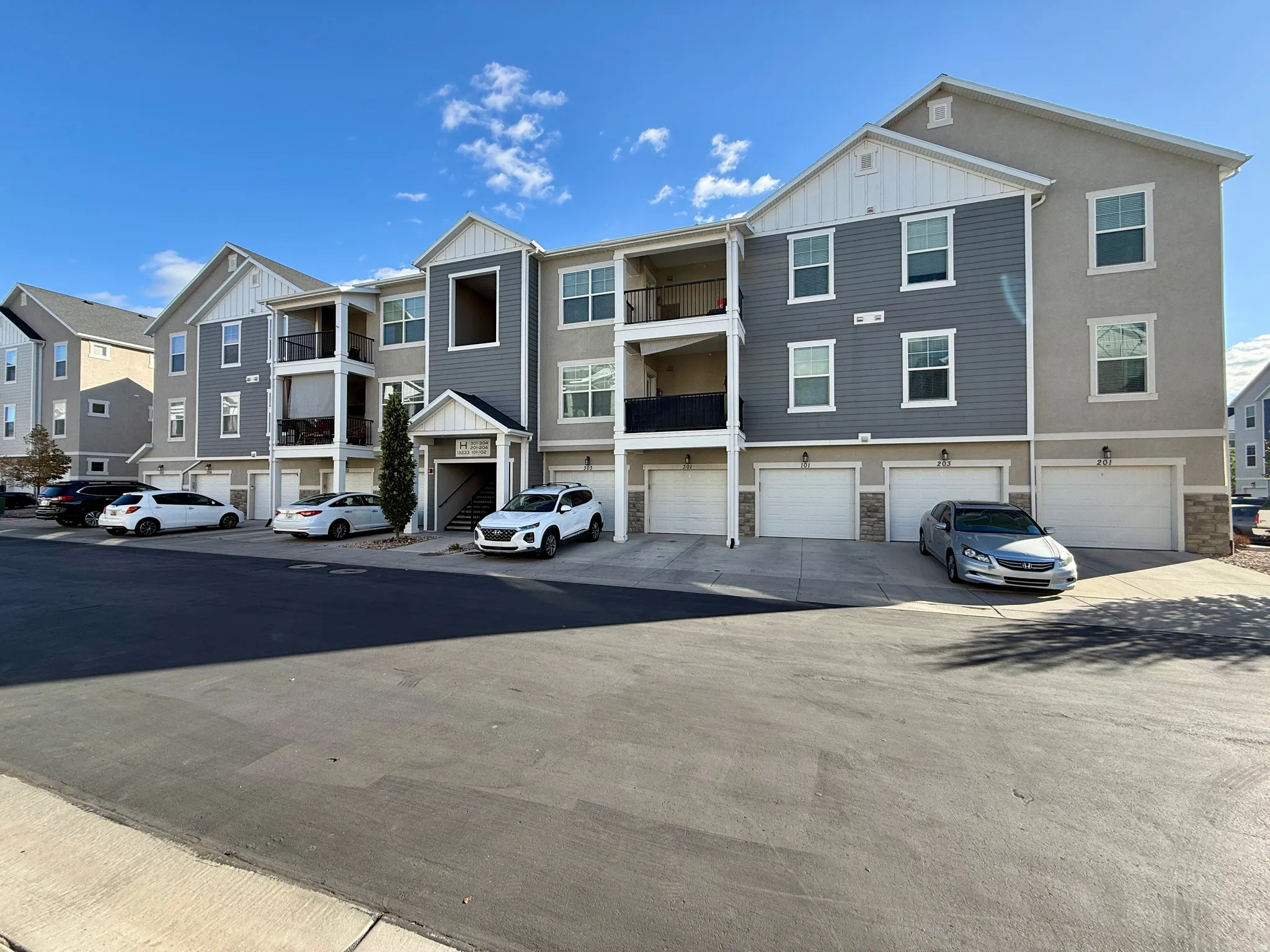 Multi-story residential building with a varied facade featuring siding and stucco