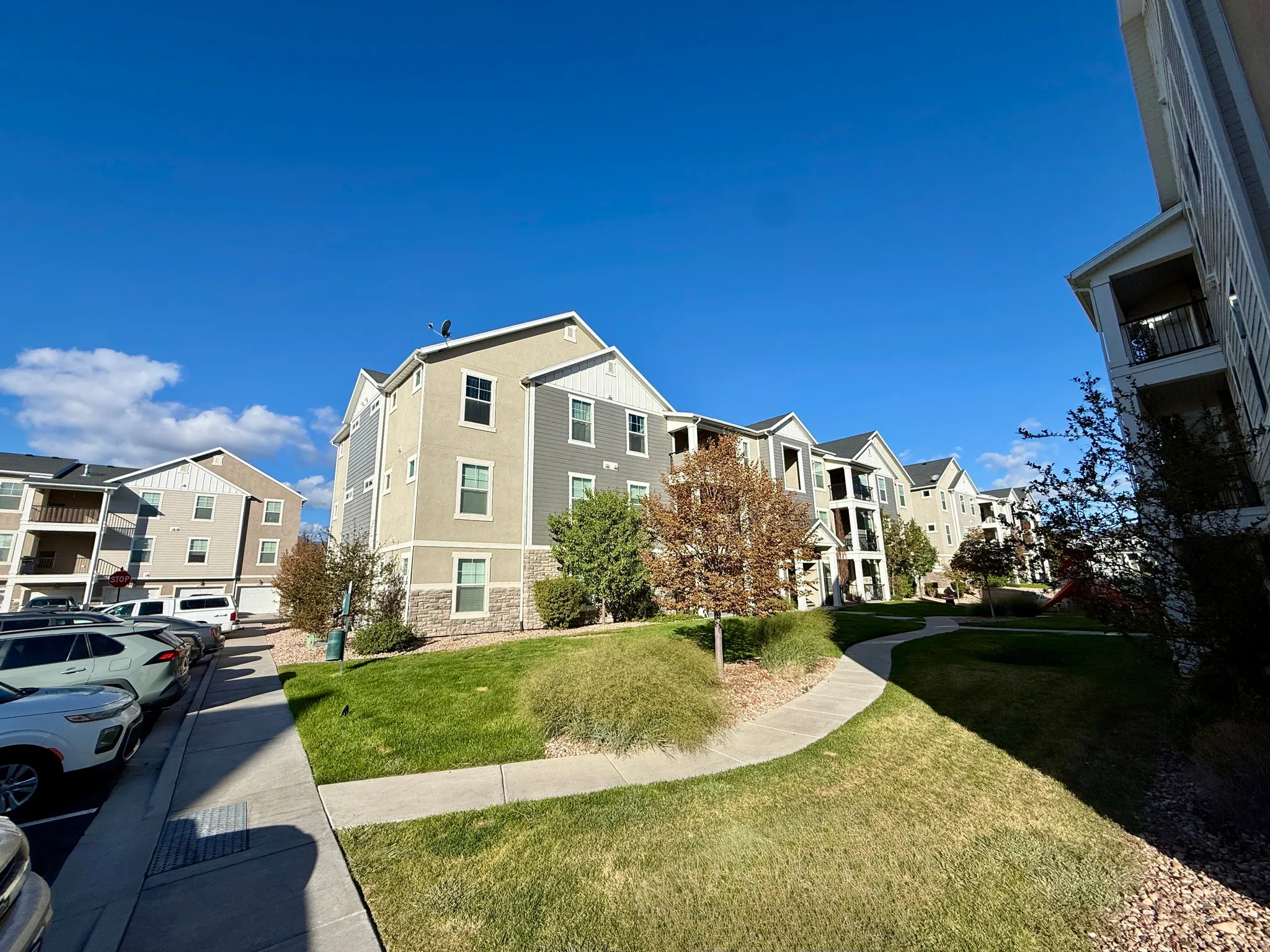 Multi-story building featuring a pitched roofline, stone veneer foundation, and multiple balconies