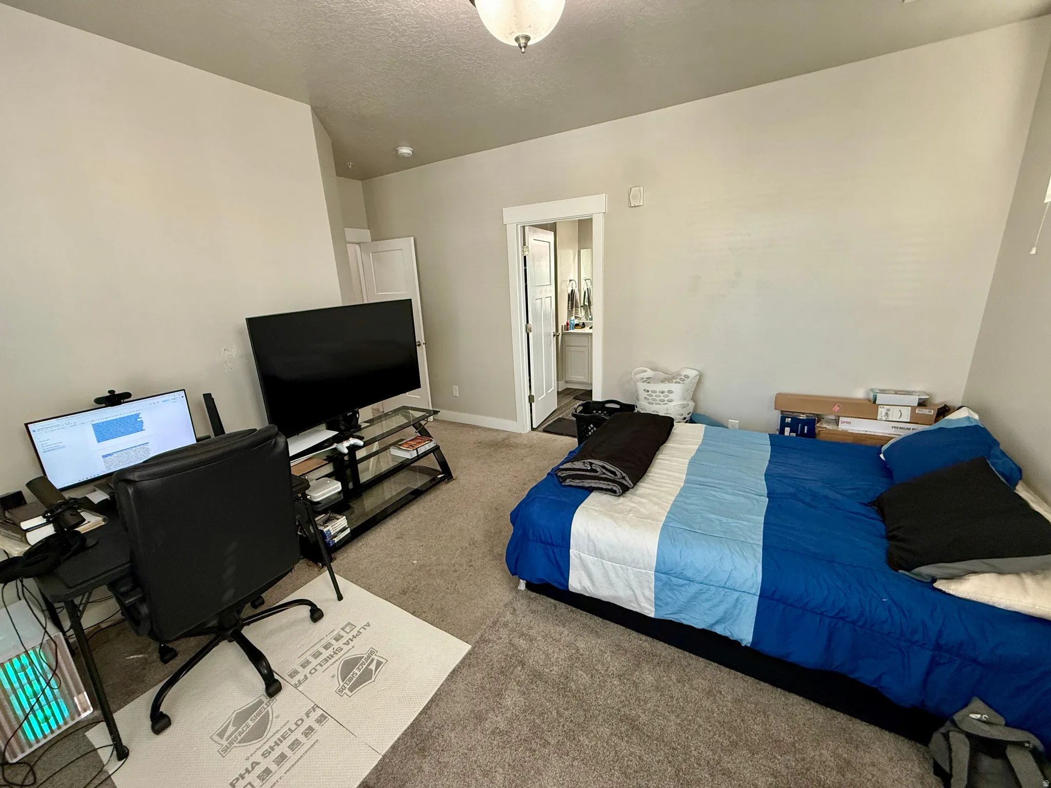 Carpeted room with a vaulted ceiling and a neutral color palette